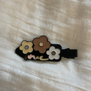 Vue détaillée d'une pince à cheveux fleurie de style coréen sur un tissu en lin blanc