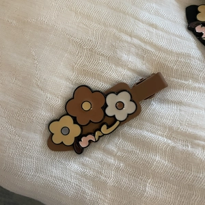 Pince à cheveux fleurie couleur thé au lait avec logo Mardi sur tissu blanc doux