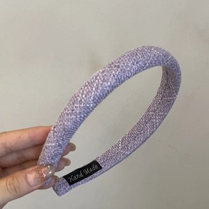 Dettaglio del cerchietto intrecciato lavanda con etichetta in tessuto Hand Made