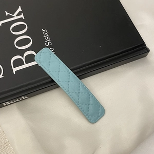 Détail d'une pince à cheveux en cuir matelassé bleu clair avec coutures élégantes