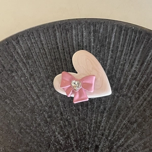 Detail of pink marble resin heart hair clip with a bow and zircon stone center