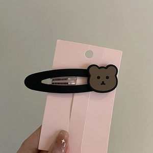 Vintage matte black hair clip with brown cartoon bear charm on display card