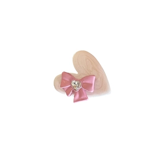 Pink heart-shaped hair clip with Y2K marble texture, a 3D bow, and a crystal rhinestone