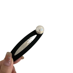 Vintage black oval BB hair clip with white pearl detail for women on white background