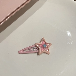 Dettaglio del fermaglio per capelli a stella rosa con paillettes e centro azzurro