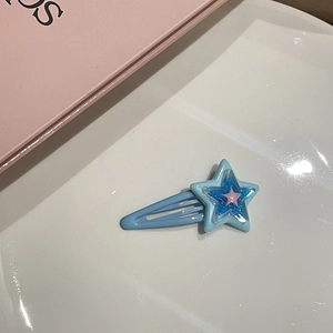 Dettaglio del fermaglio a stella a strati rosa e blu con finitura glitterata lucida