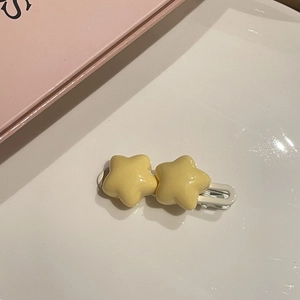 Dettaglio del fermaglio per capelli a stella gialla con doppie stelle in resina e metallo
