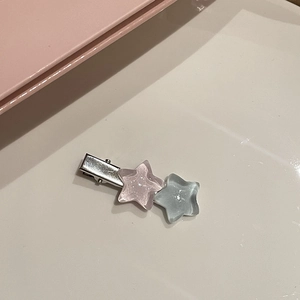 Dettaglio del fermaglio per capelli con stelle rosa e grigio-blu e clip in metallo