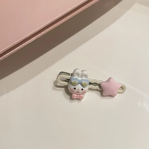 Dettaglio di un fermaglio per capelli con coniglietto in resina, occhiali e stella rosa