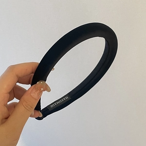 Détail d'un serre-tête en éponge noire fait main avec une texture satinée lisse