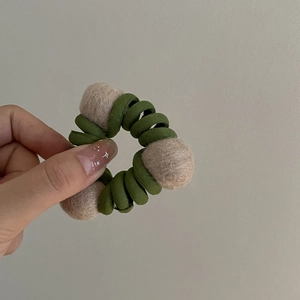Elastico per capelli a spirale verde con palline di feltro beige stile foresta naturale