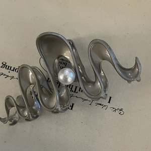 Silver metallic wave hair claw clip featuring a white pearl detail for women