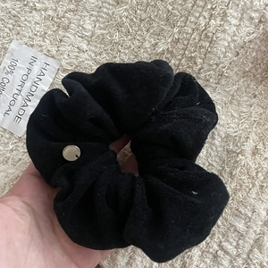 Detail of black cotton scrunchie with gold accent and 100% cotton handmade tag