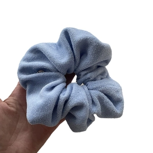 Light blue towel fabric scrunchie with soft fiber texture and plush pleated design
