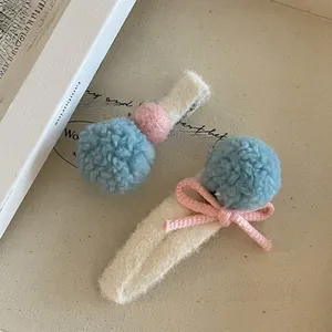 Detalle de pinzas de pelo de felpa con lana de cordero suave, pompones azules y lazos lindos
