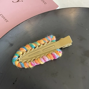 Dettaglio ravvicinato di un fermaglio per capelli in lana intrecciata colorata
