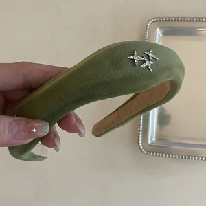 Detail of olive green velvet headband with silver rhinestone stars on padded sponge base