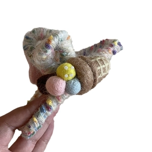 Handheld view of a large wool felt shark hair claw clip with colorful ice cream decor