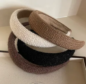 Detail view of thickened tweed headbands in cream, beige, and brown with shimmering threads