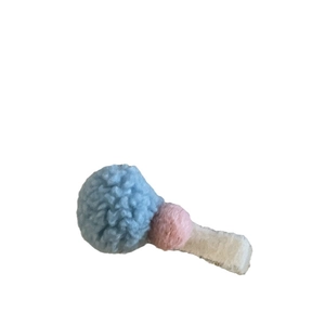 Lindo clip de pelo de felpa con pompones azul y rosa sobre base de tela color crema