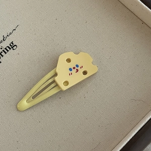 Vue macro détaillée d'une pince à cheveux jaune en forme de fromage avec sourire cartoon
