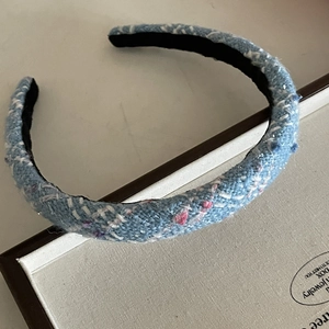 Elegant blue tweed headband with colorful woven patterns and subtle glitter accents