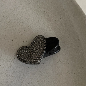 Pince à cheveux cœur vintage avec strass gris sur une assiette en céramique épurée
