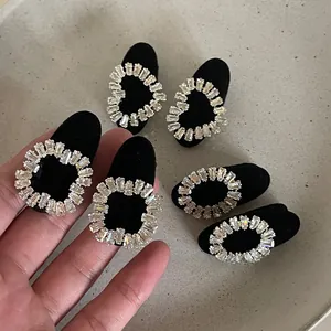 Détail d'une pince à cheveux en velours noir élégante avec boucle en cristal et strass brillants