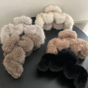 Macro shot of large plush hair claw clips in beige grey coffee and black faux fur texture