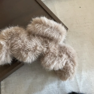 Close-up of khaki plush faux fur scrunchie with soft fluffy texture for winter