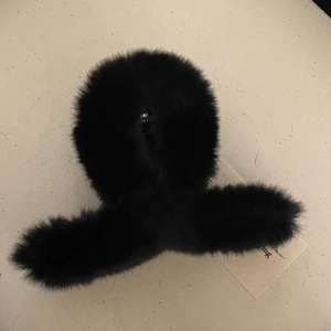 Vue détaillée de la texture douce en peluche noire d'une grande pince à cheveux
