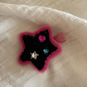 Close-up of handmade Y2K star hair clip with pink faux fur and colorful gem embellishments