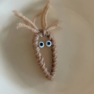 Handmade knitted brown sprout hair clip with cute cartoon eyes and creative design