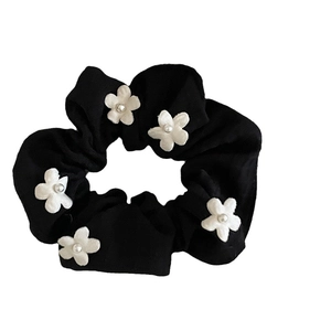 Elegant black scrunchie with white embroidered flowers and pearls for hair styling