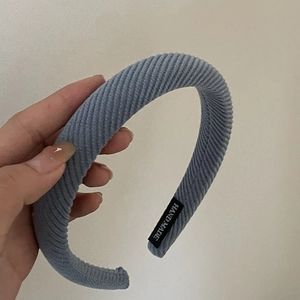 Detail of blue corduroy headband showing vertical texture and handmade inner label