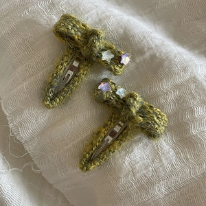 Set of two green knitted bow hair clips with decorative colorful stars for girls
