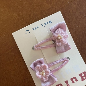 Close-up of pink velvet BB hair clips with handmade crochet flowers and pearl accents
