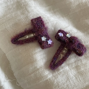 Detail view of purple fabric bow hair clips with colorful star sequins and metal clips