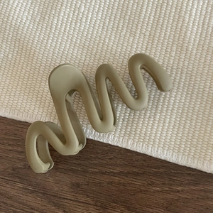 Minimalist matte olive green wavy hair claw clip on waffle fabric and wood