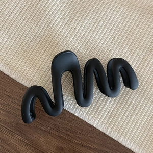 Macro detail of large matte black wave hair claw clip with anti-slip grip and strong spring