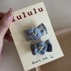 Detail of handcrafted blue crochet flower hair clips with pearls and velvet bows