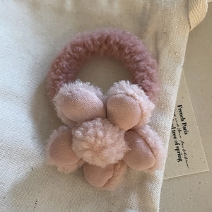 Dettaglio dell'elastico per capelli con fiore di peluche rosa e consistenza in pile morbido