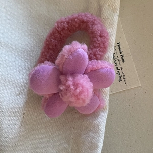 Dettaglio ravvicinato dell'elastico per capelli con fiore di peluche rosa e viola morbido