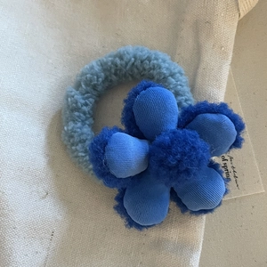 Vista dettagliata dell'elastico per capelli con fiore di peluche e morbido vello