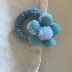 Dettaglio di elastici per capelli con fiori di peluche in tessuto blu chiaro e scuro