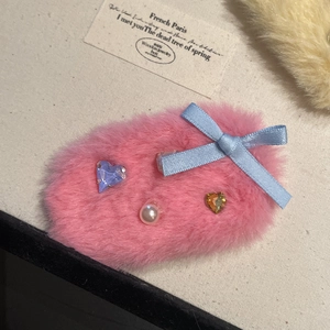 Barrette en fausse fourrure rose avec gemmes en cœur, perle et nœud bleu sur fond beige clair