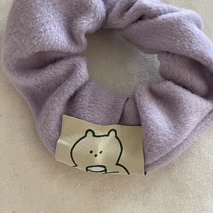 Gros plan d'un chouchou en peluche violette douce avec une étiquette d'ours mignon