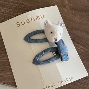 Blue denim hair clip featuring a white plush bear head on a white display card