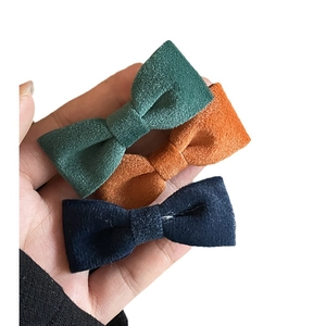Three-piece velvet bow hair clip set in vintage green, bright orange, and navy blue