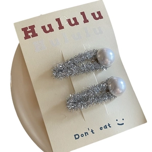 Pair of cute silver textured hair clips with pearls on beige display card
